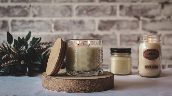 a white candle with flickering flames in front of a brick wall