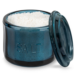 Blue glass salt container with white salt inside on a white background