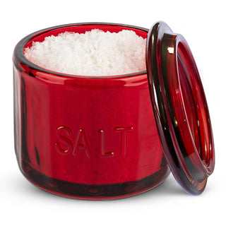 Red salt container with white salt inside on a white background