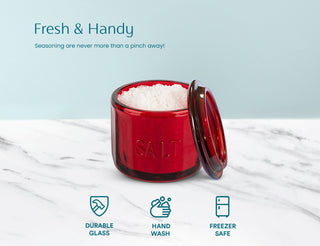 Red salt container with lid on a marble surface, featuring text and icons about product features.
